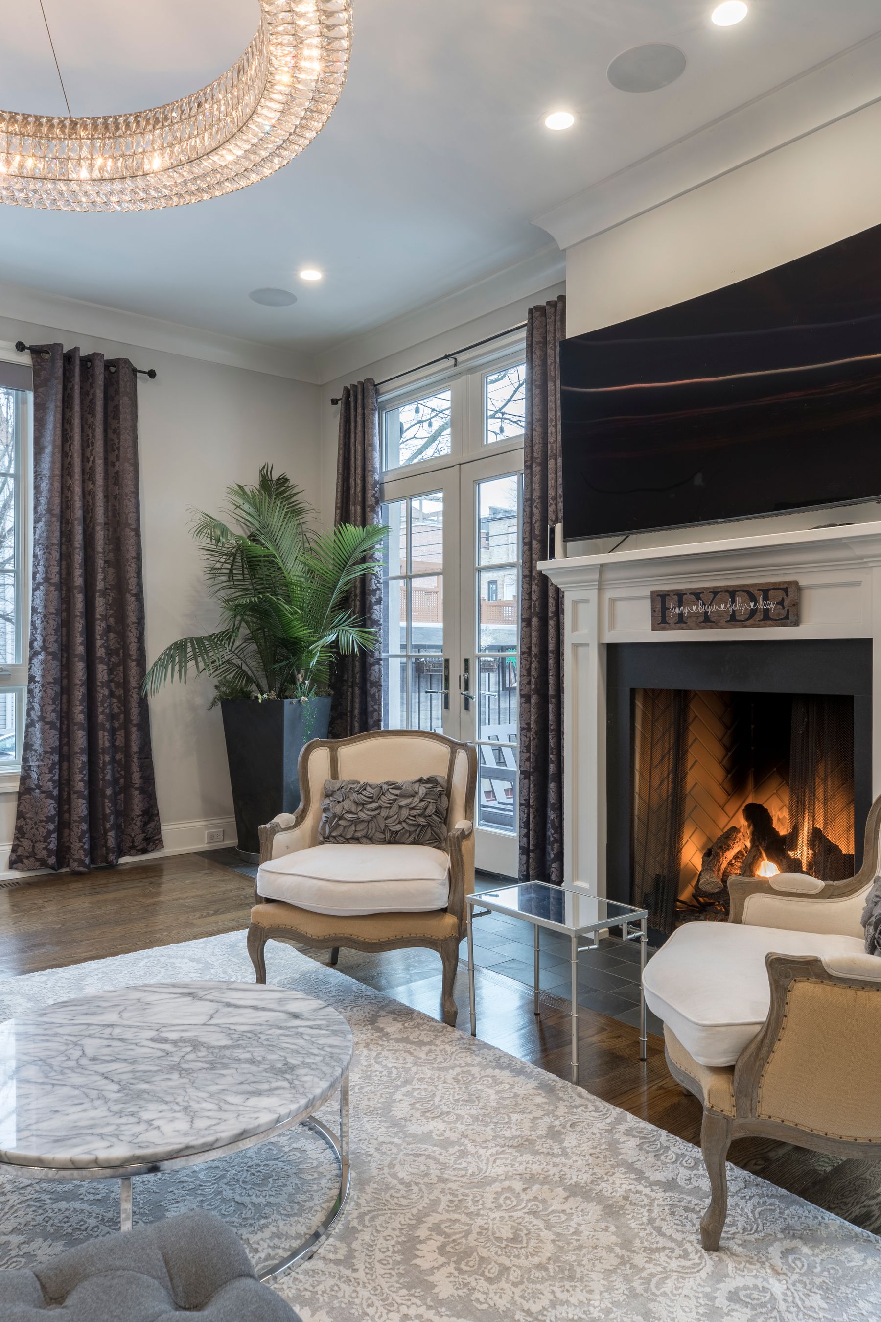 A living room with a fireplace, deep seating and layered textiles