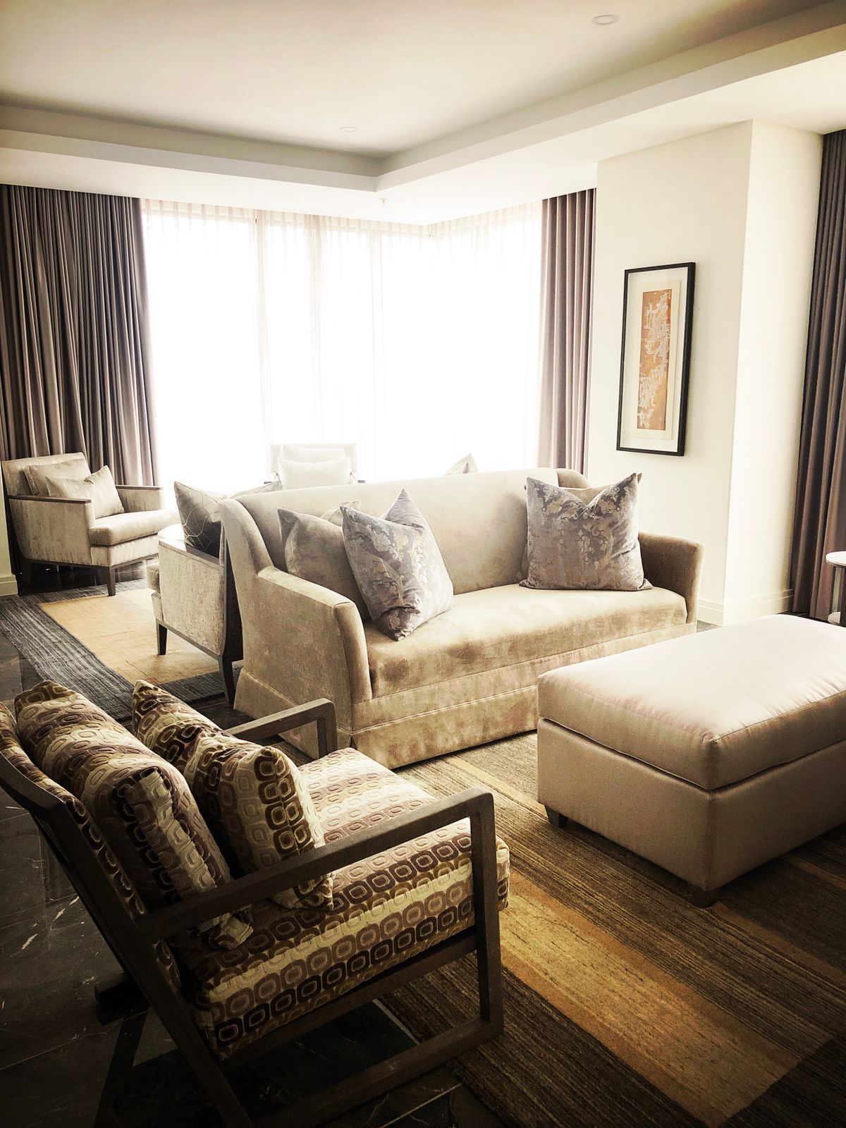 A bright living room with pale sofas and full-height windows