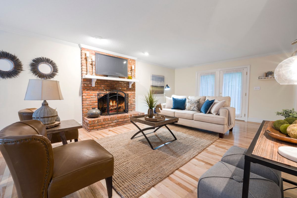 A sitting room with a brick fireplace and warm low lighting