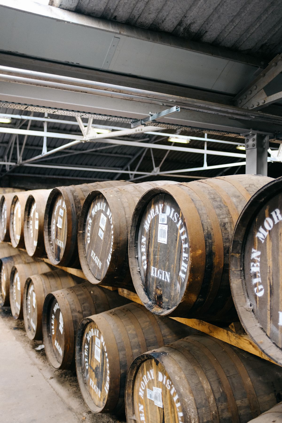 Charred oak barrels racked in rows down the length of the rickhouse