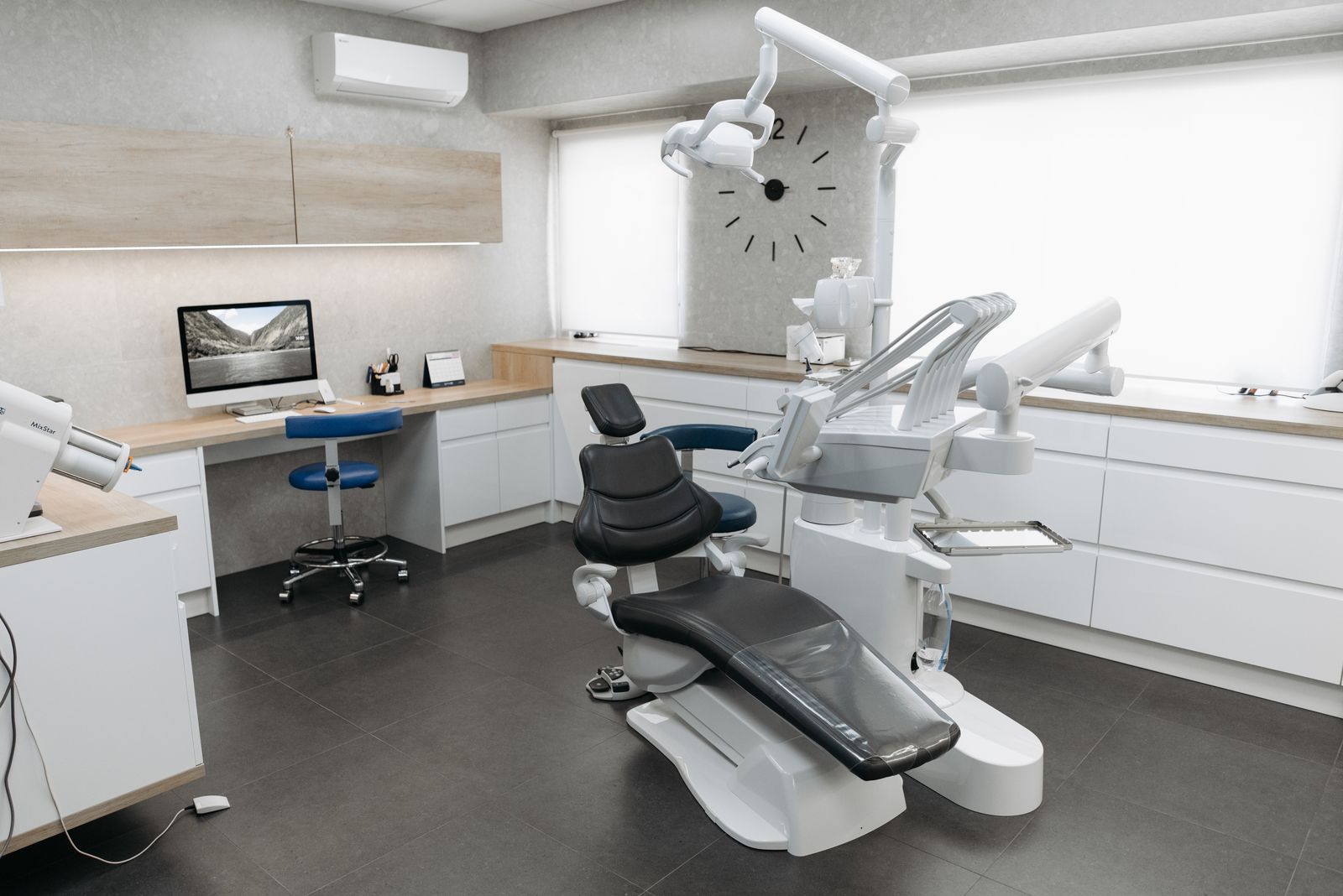 A bright treatment room with a modern dental chair and equipment
