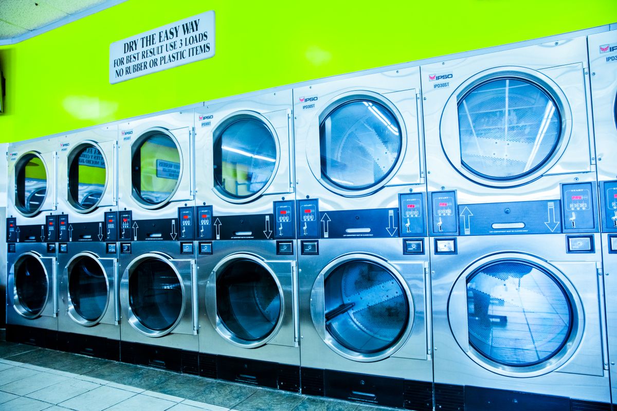 A bank of stainless dryers with their doors open