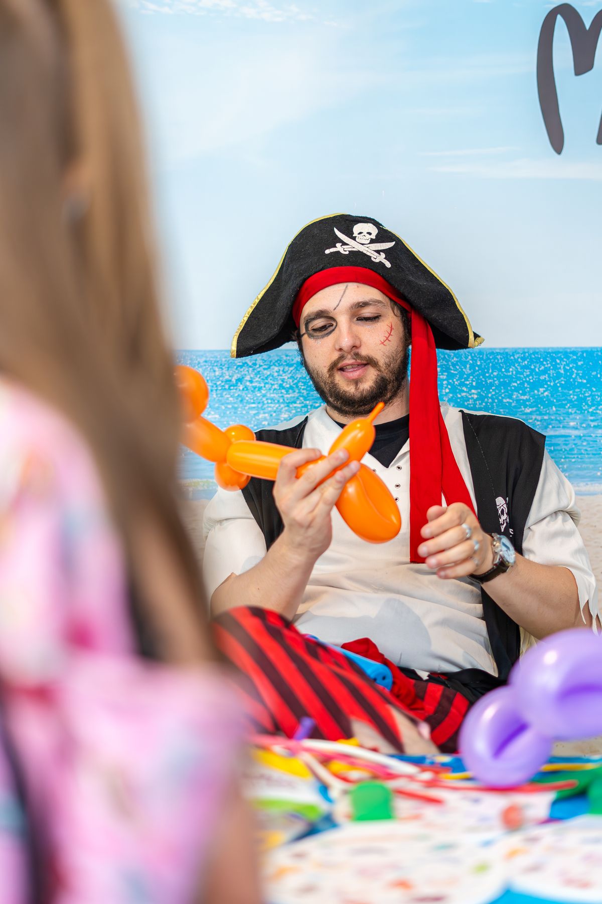 An entertainer twisting balloon animals for a group of children