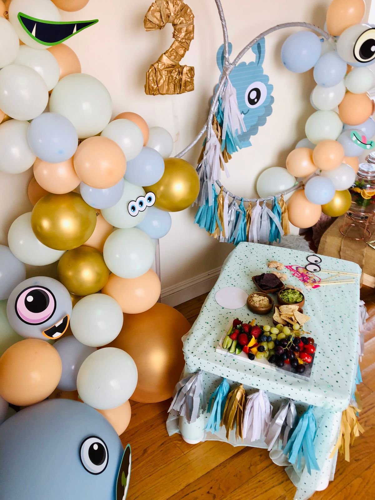 A decorated party table with balloon arch and snacks
