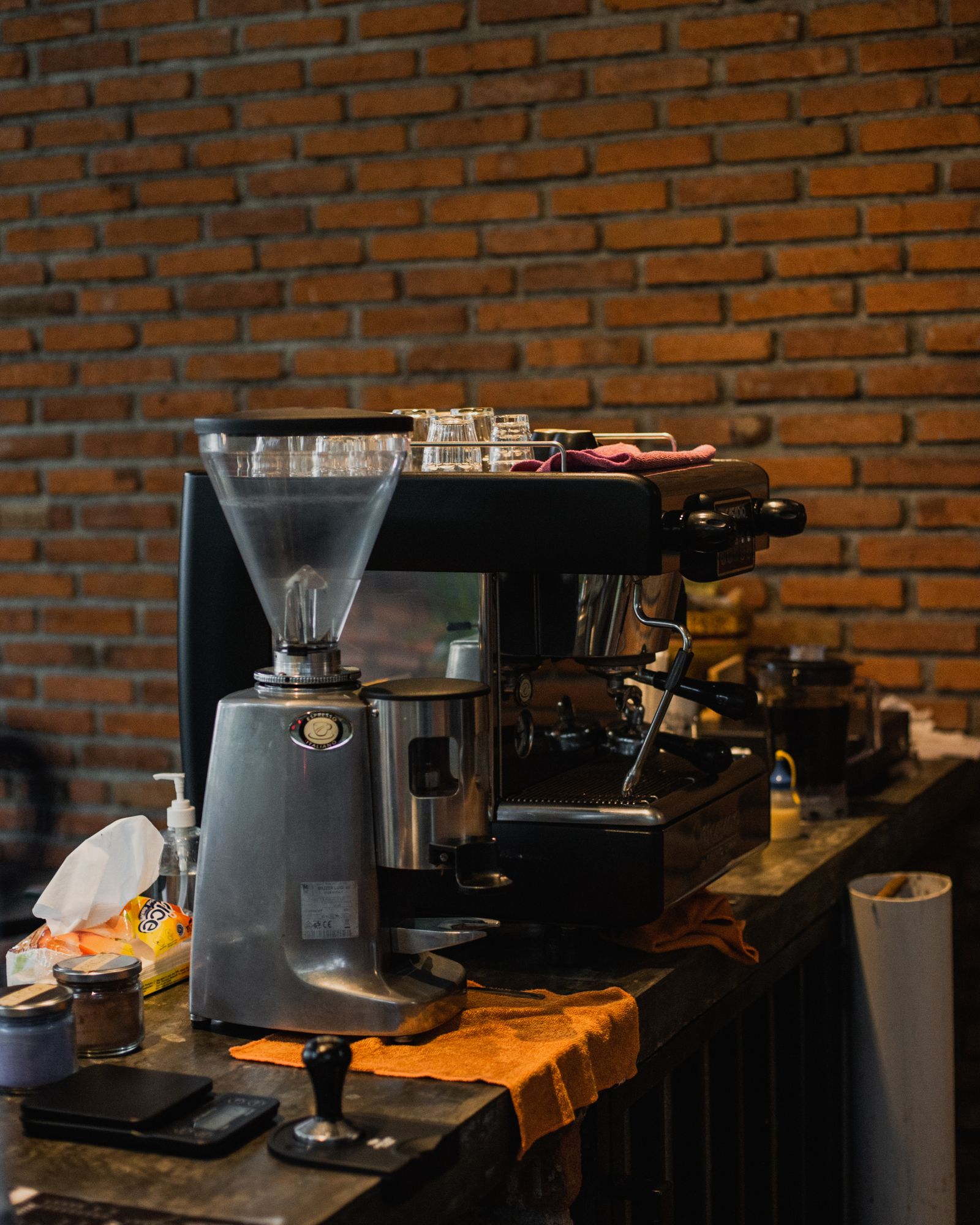 The espresso bar: machine, grinder and cups lined up along a wooden counter