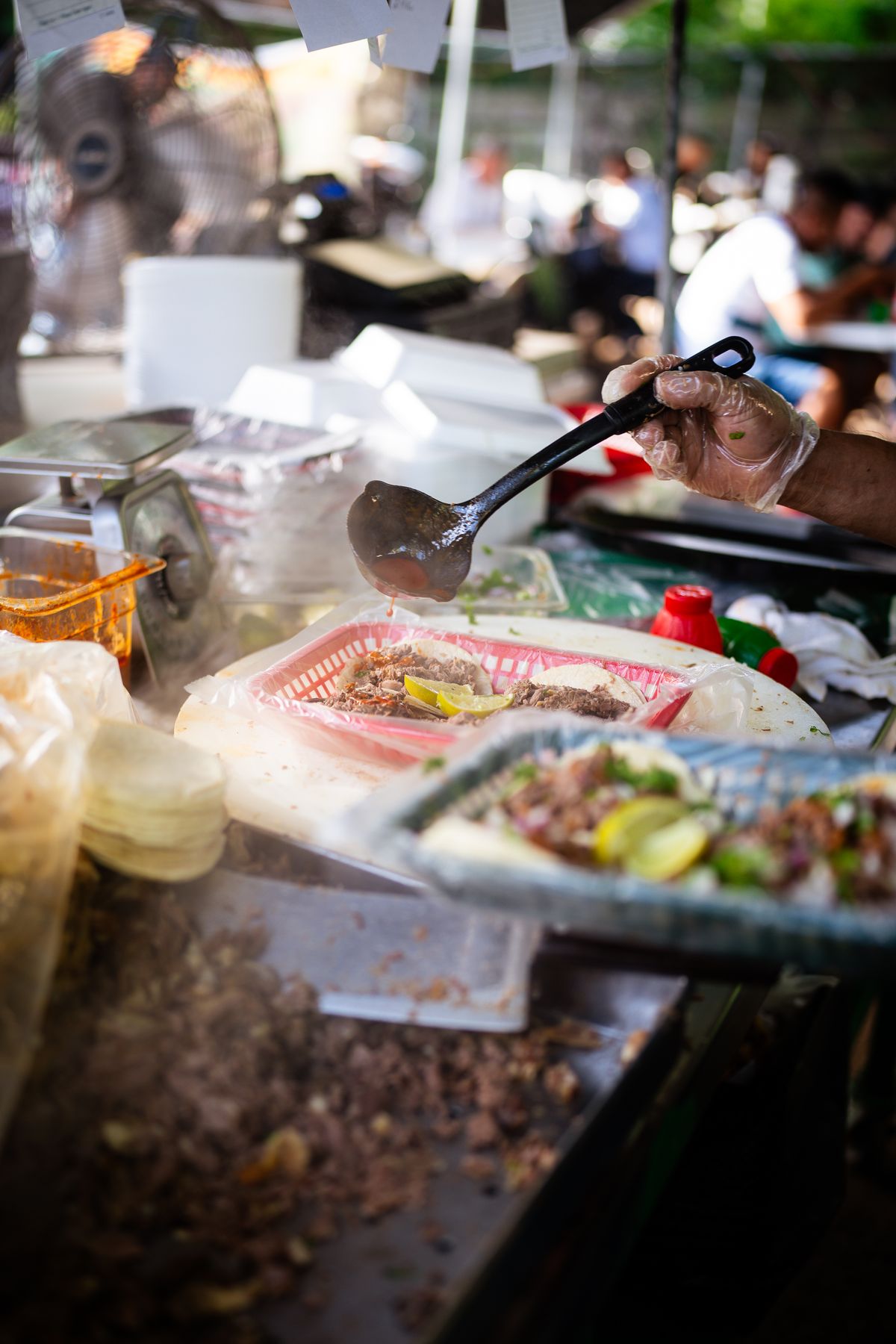 A cook assembling tacos to order at the truck window