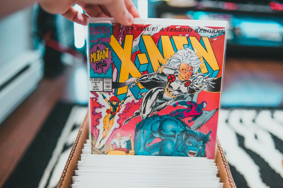Hands flipping through a longbox of bagged and boarded comics