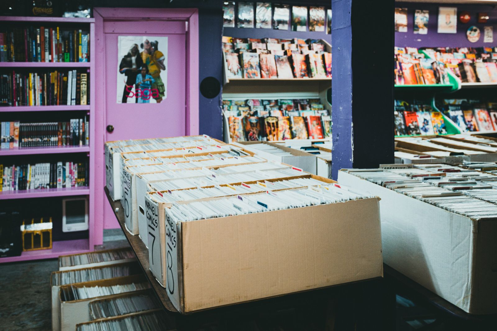 Comic shelves and longboxes filling a shop, spines and covers facing out