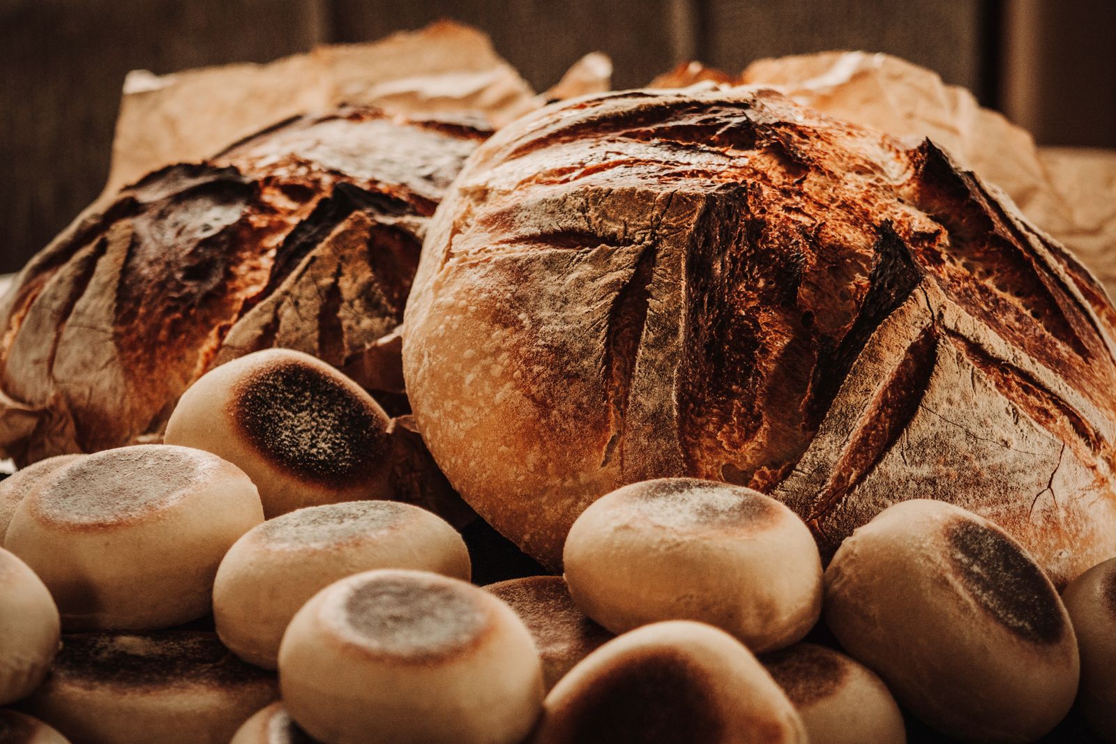 Freshly baked rustic sourdough loaves cooling in a basket, crusts dark and split