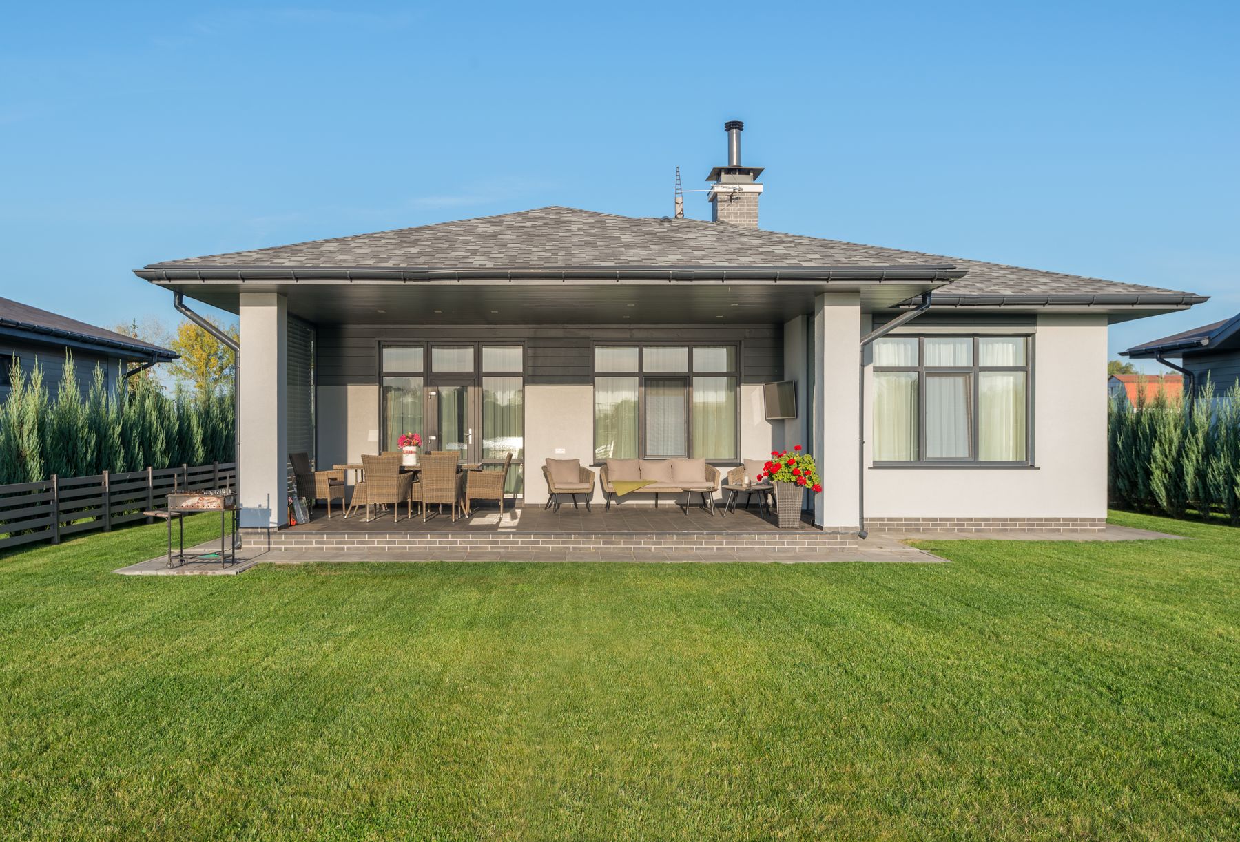 A wide, freshly cut back lawn running up to a house with a covered patio