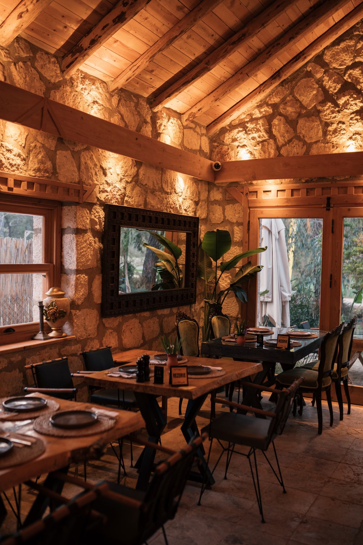 Set tables under wooden beams, ready for service
