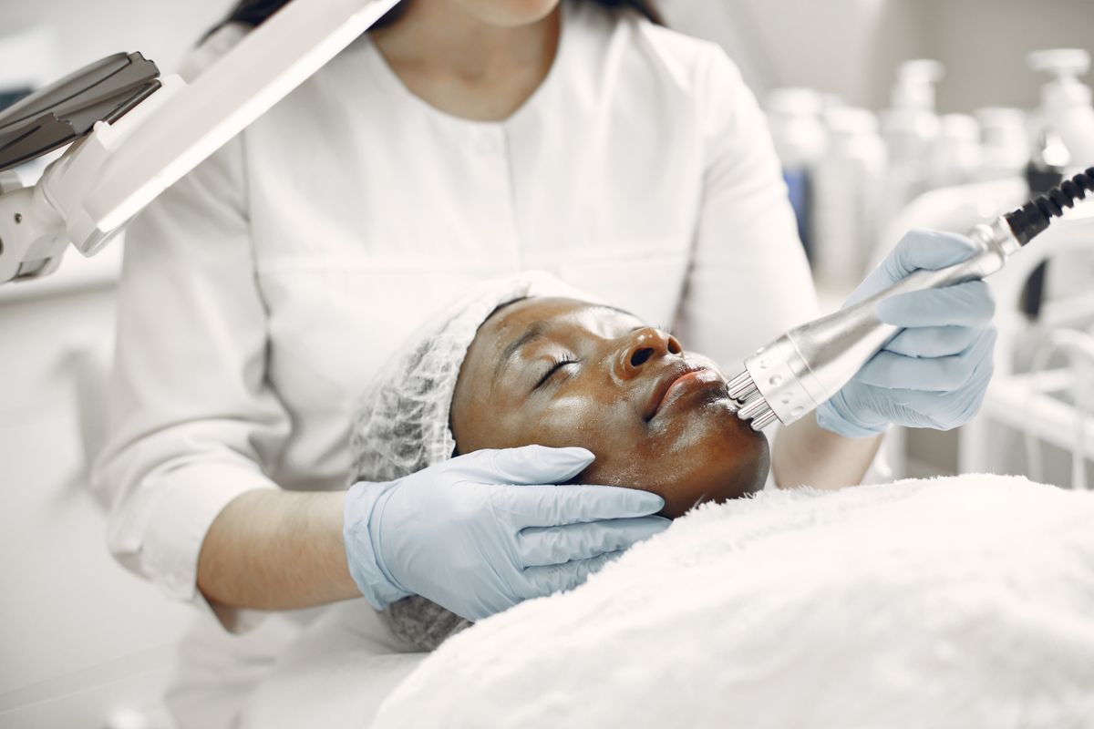 A practitioner performing a treatment with a handheld device while the client rests