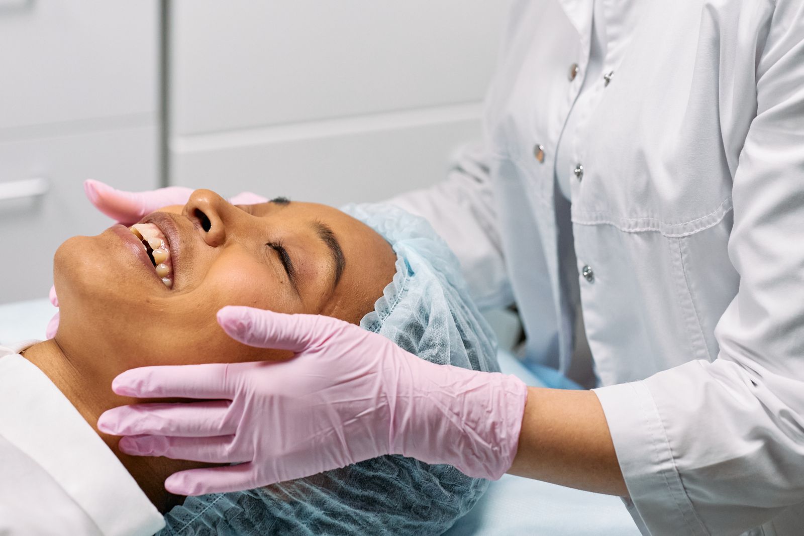 A client receiving a facial treatment in a calm, softly lit clinic room