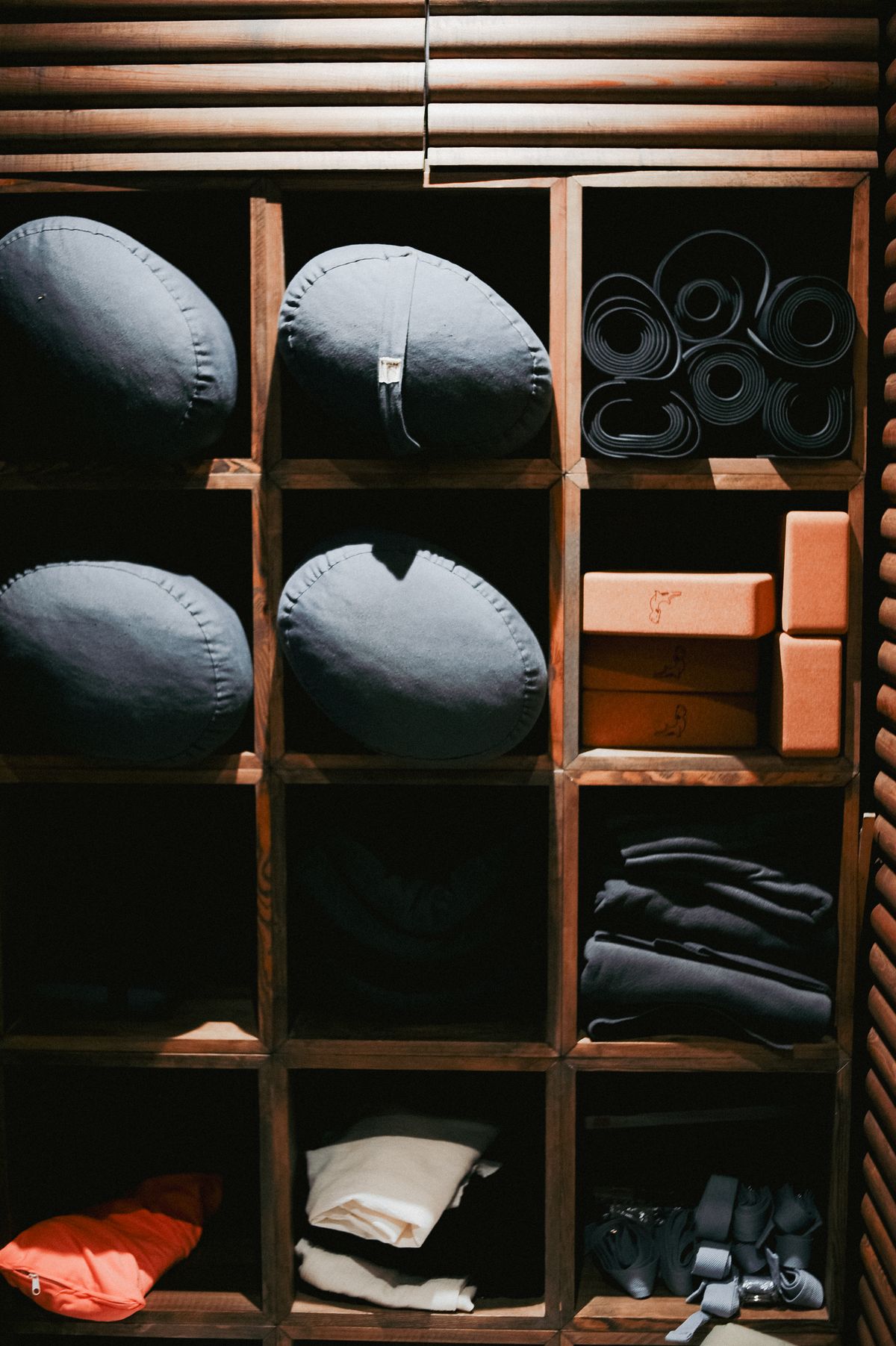 Bolsters, blocks and folded blankets stacked on wooden shelves