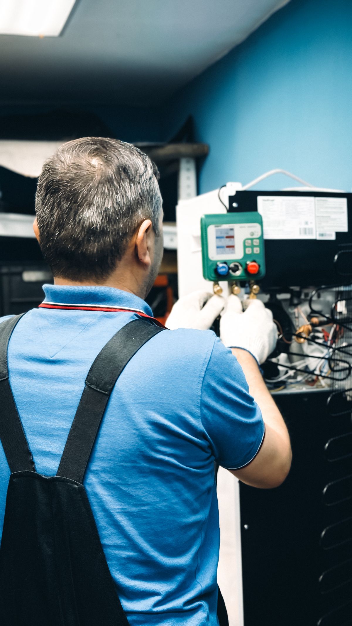 A technician servicing an indoor air handler