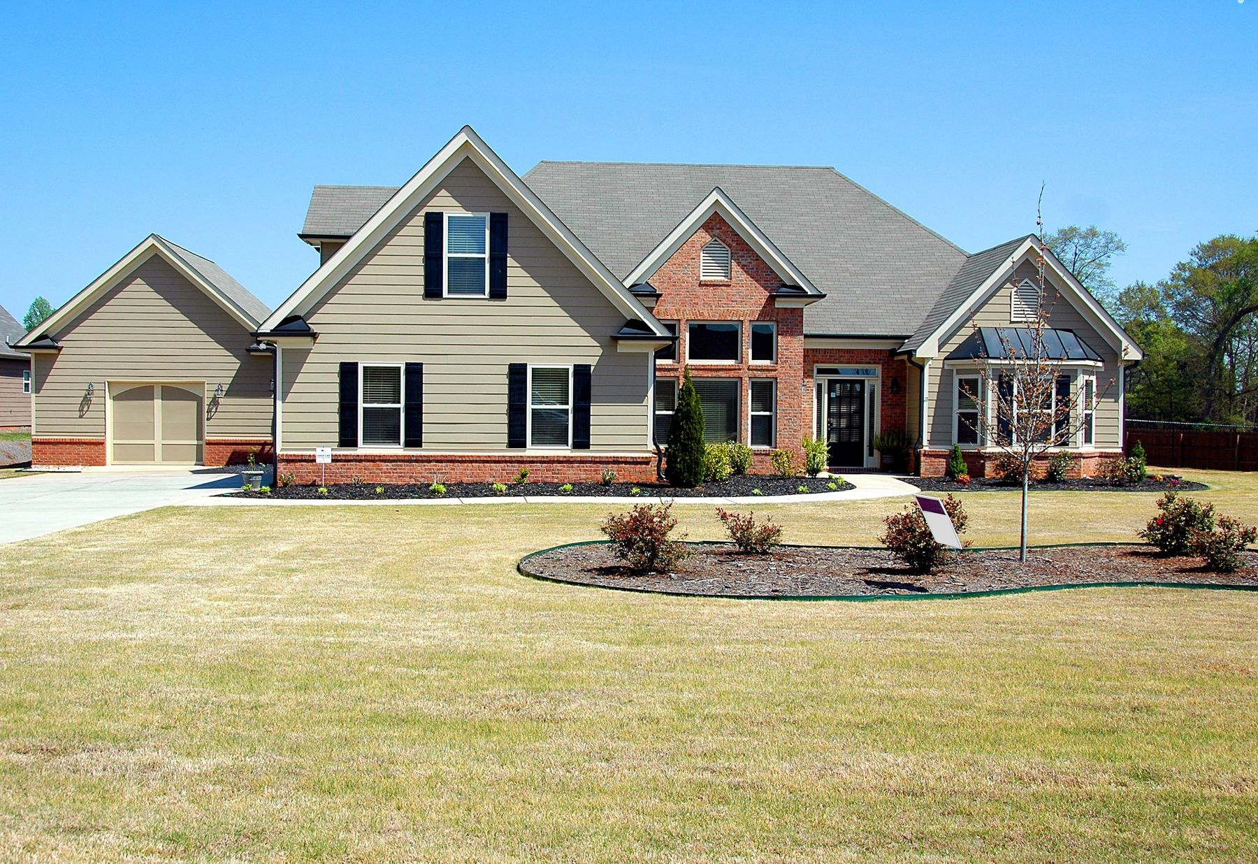 A suburban family house with a wide lawn and driveway at golden hour