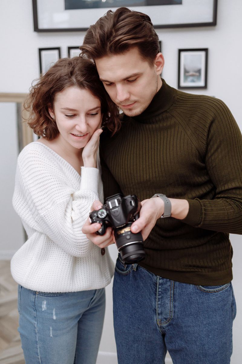 June and Theo Marlowe standing together in the studio, looking at the back of a camera